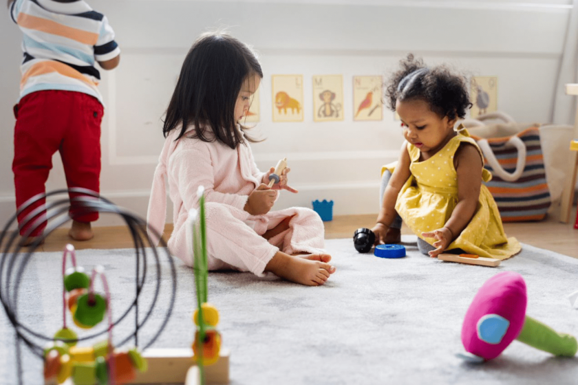 A group of children playing with toys in a playroom.
